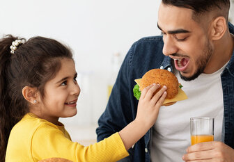 Mädchen und Vater essen gemeinsam
