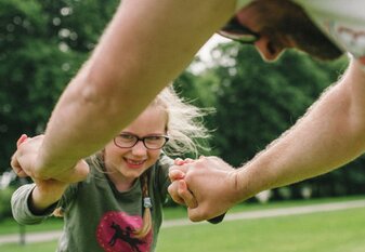 Mädchen spielt mit Vater im Park