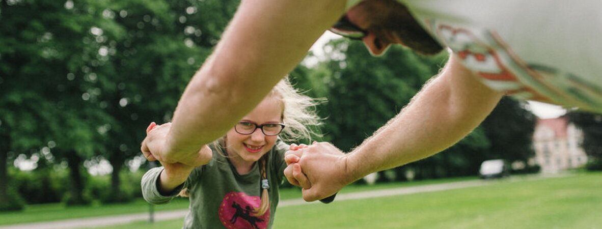 Mädchen spielt mit Vater im Park