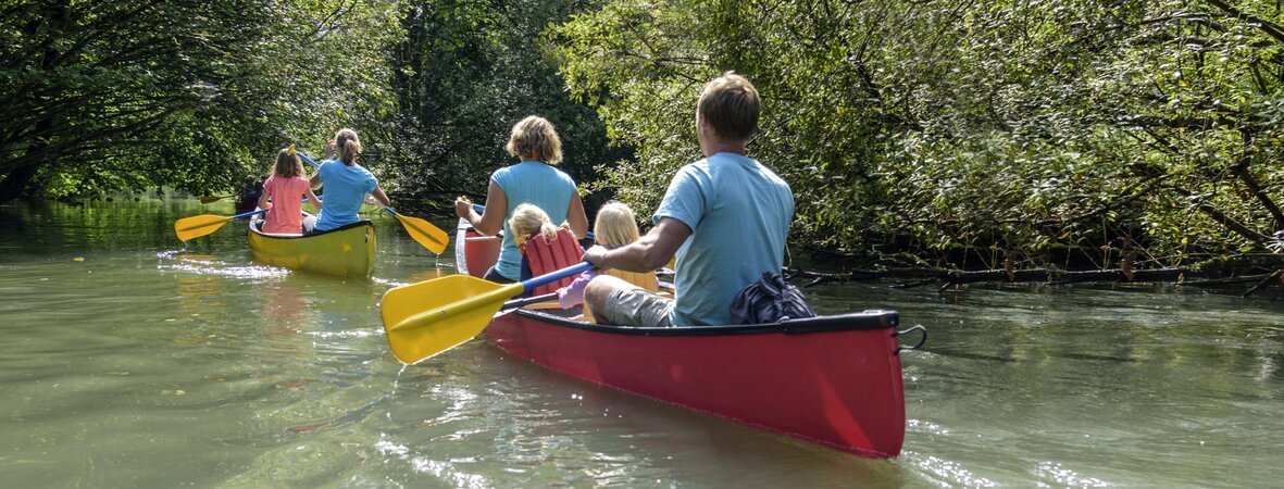 Familie paddelt im Kanu auf Fluss