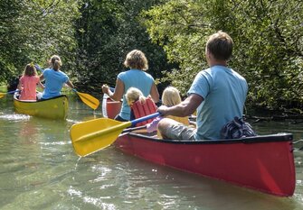 Familie paddelt im Kanu auf Fluss