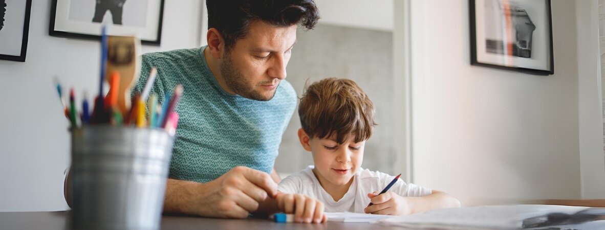 Vater hilft Jungen bei Hausaufgaben